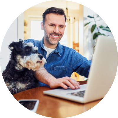 a man and his dog look at a laptop